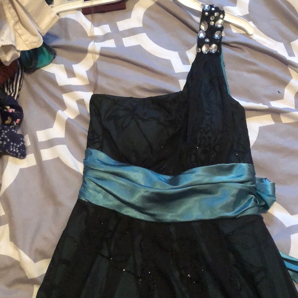 Black dress with green/teal waist strap.